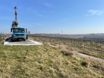 Auf dem Bild sind dich Hochheimer Weinberge zu  sehen. Links steht ein LKW mit Bohrgerät auf einer an die Weinreben angrenzenden Wiese. 